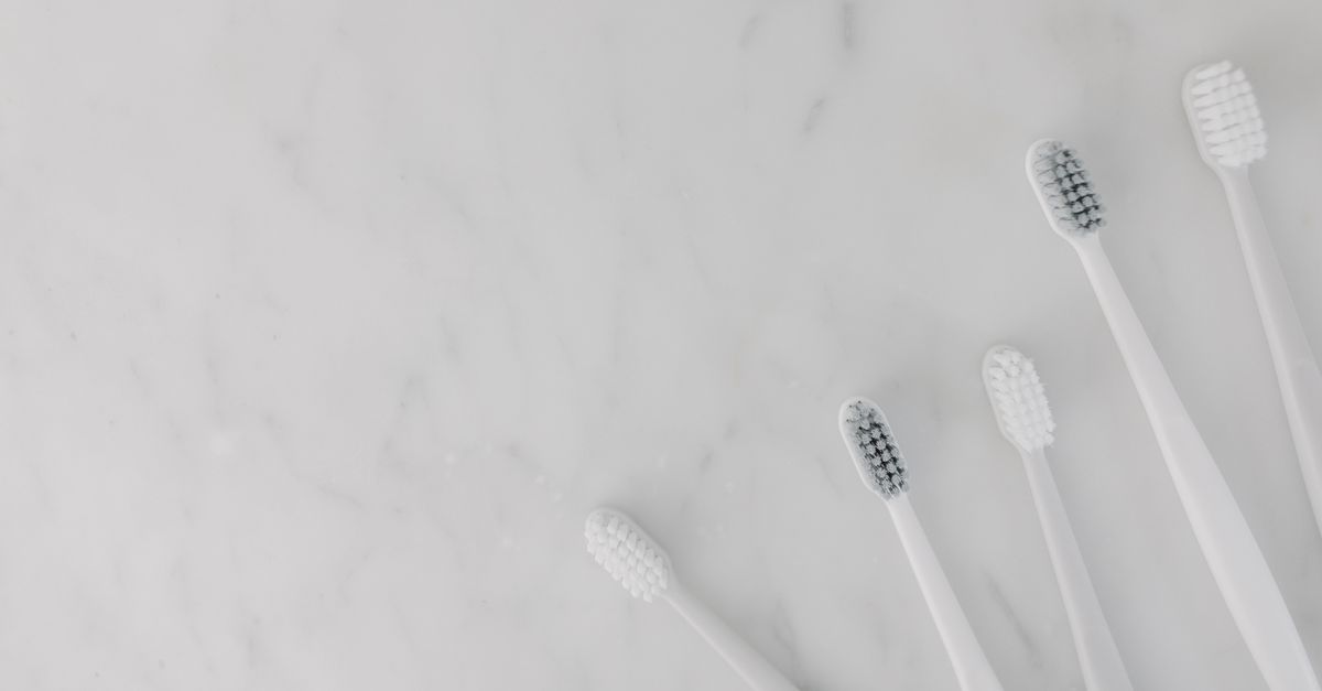 Minimalist display of toothbrushes on a marble surface in natural light